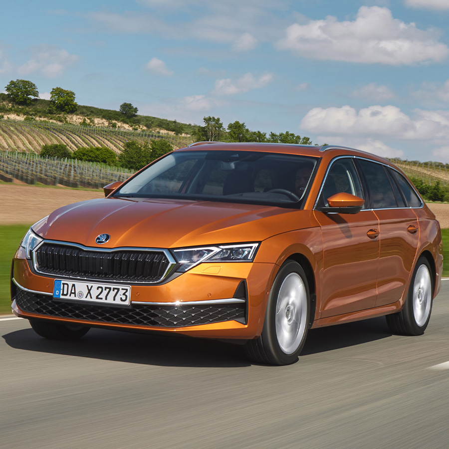 Ein orangener Skoda Octavia Combi in der Dreiviertelansicht von vorne beim Fahren auf einer Landstra&szlig;e mit hohem Tempo