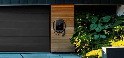 E-Ladestation an einem modernen Haus montiert mit Holzpanelen